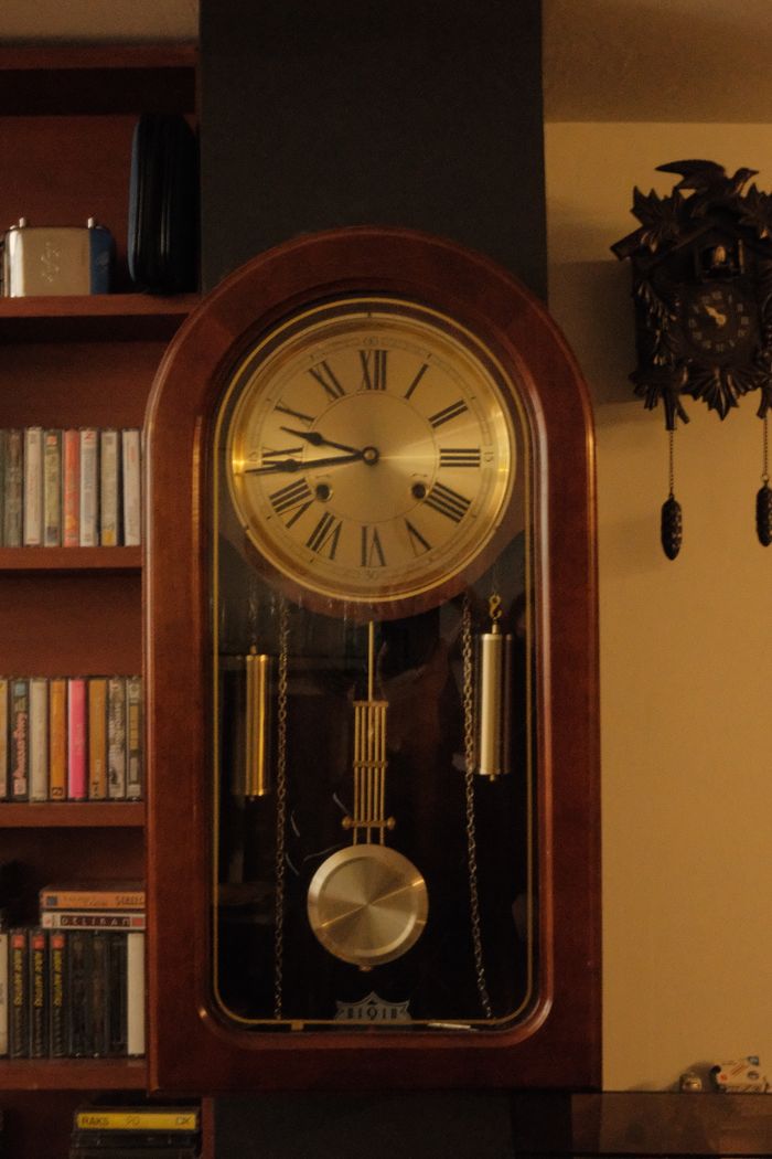 Classic vintage wall clock with roman numerals in a warm, inviting setting.