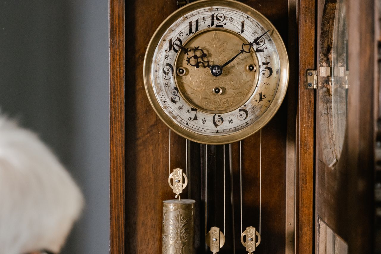 A vintage wall clock with ornate details, evoking a sense of nostalgia and timeless elegance.